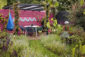 Garden grass with pink wooden fence and furniture