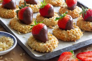 Almond cookies with chocolate covered strawberries on baking tray