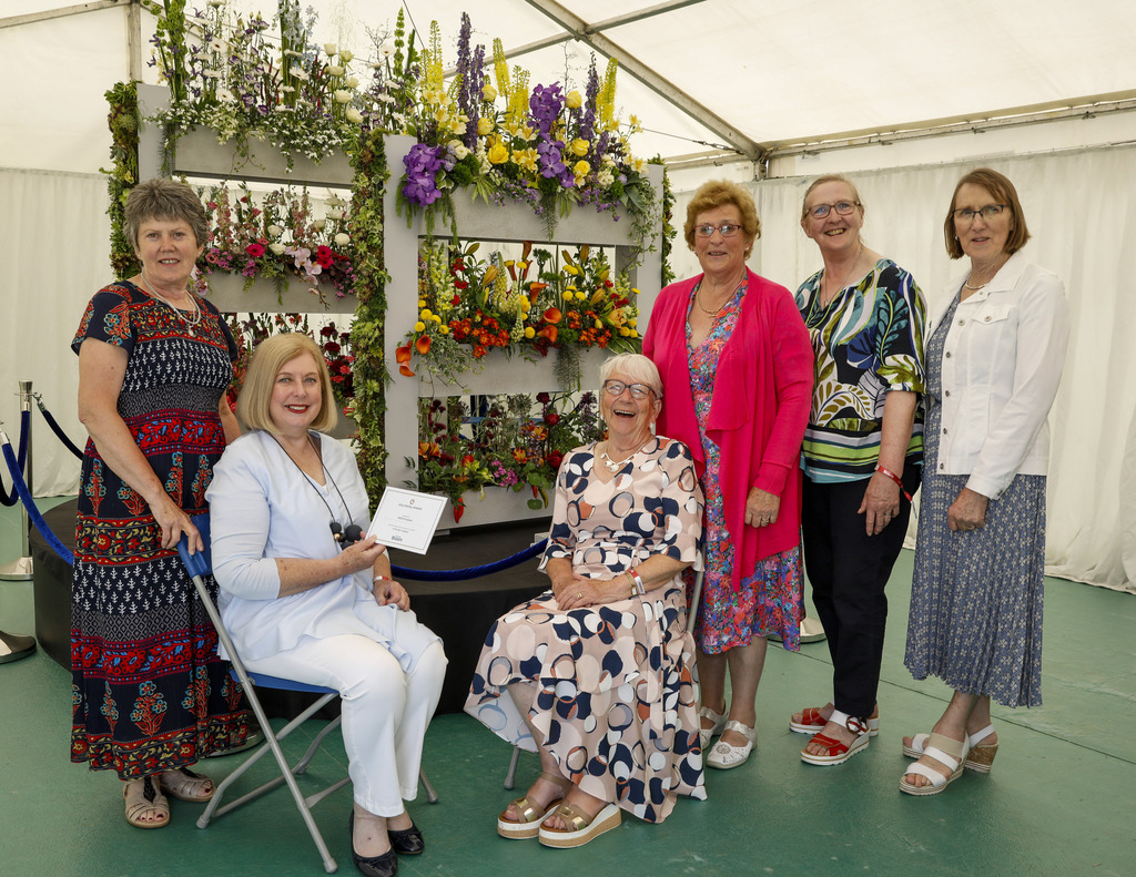 Floral artists stand around their winning piece of floral art at Bloom 2023