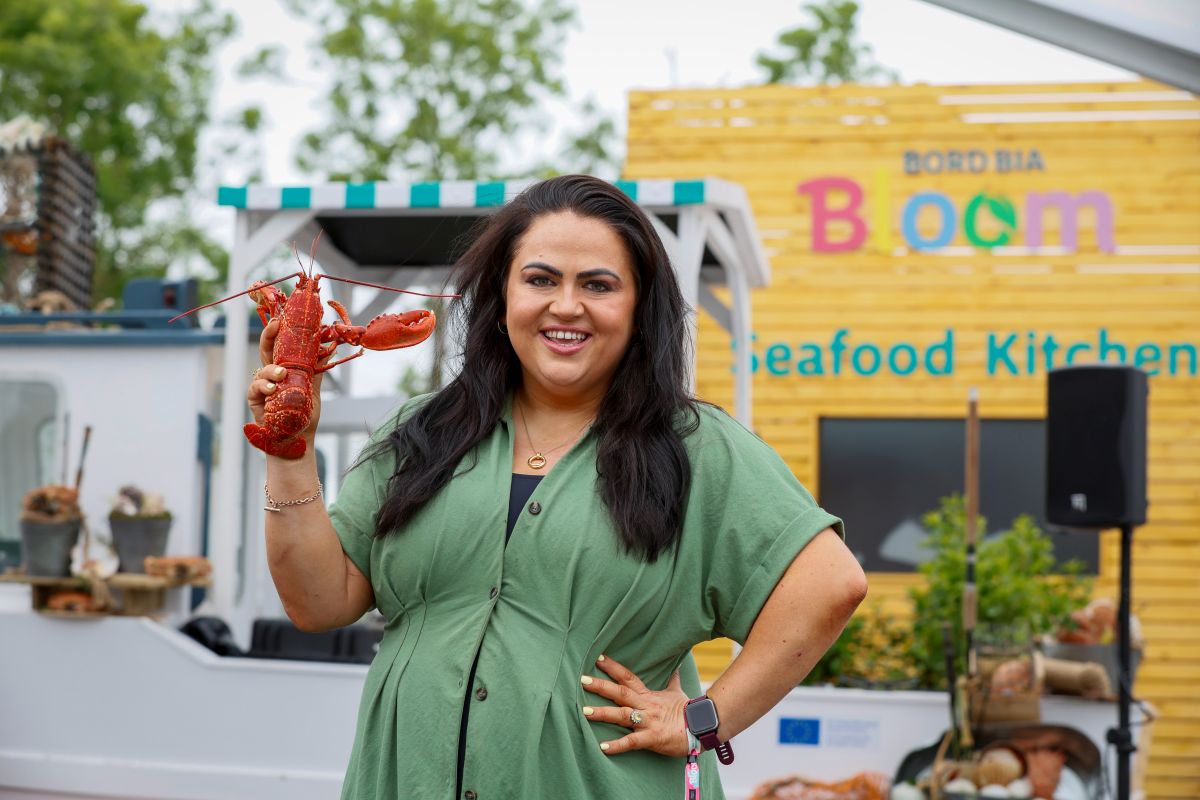 Woman at garden festival holding a lobster.
