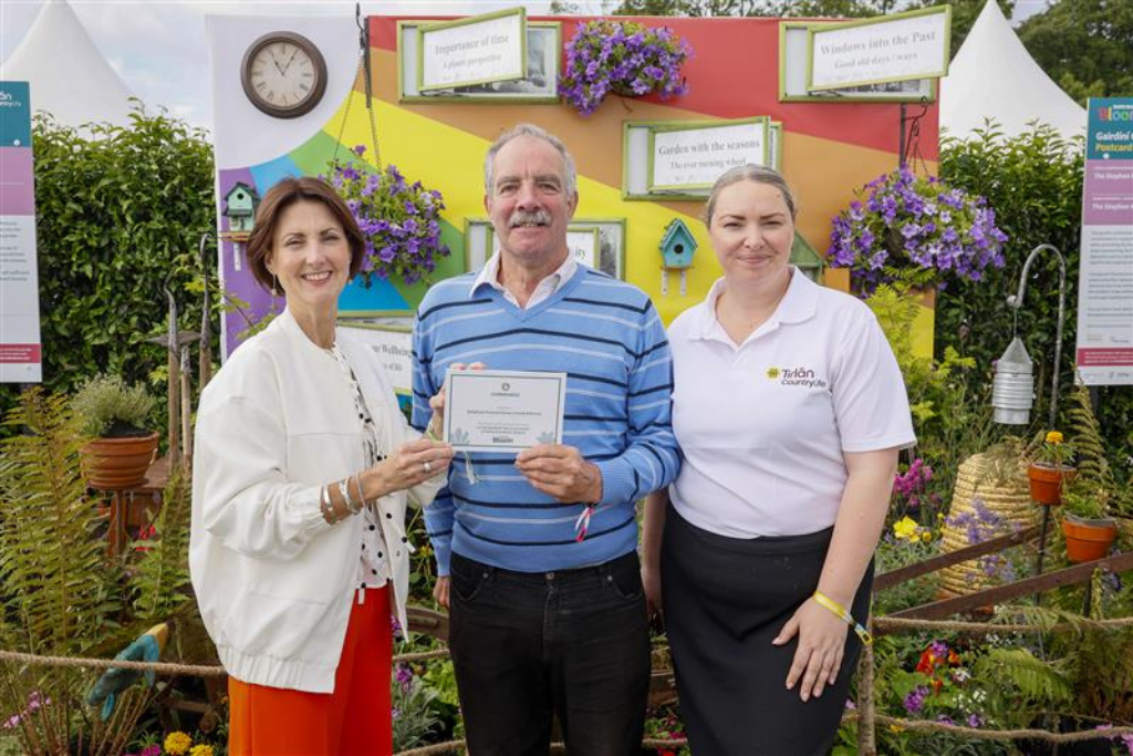 Three people standing with award